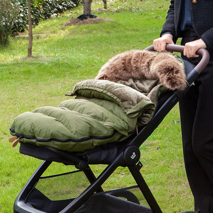 Chancelière évolutive de couleur vert installé sur une poussette