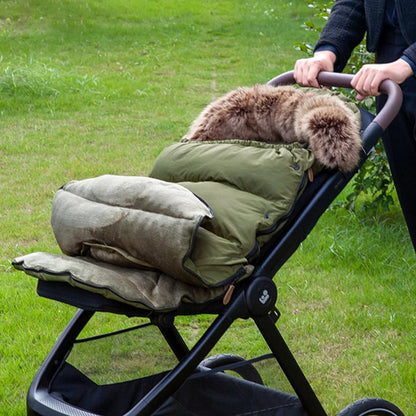 Chancelière évolutive de couleur vert installé sur une poussette avec un intérieur doux