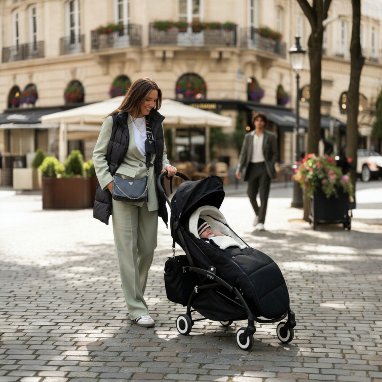 maman promenant son bebe dans une poussette, le bebe est allongé dans sa Chancelière poussette noir