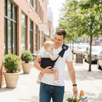 Papa_promenant_son_bebe_dans_une-Écharpe de portage bébé_noir_en_ville_un_jour_d_ete