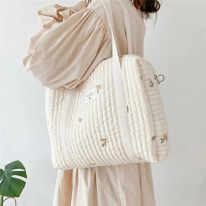 Sac à langer pratique beige accroché sur une chaise – AstuceBambin